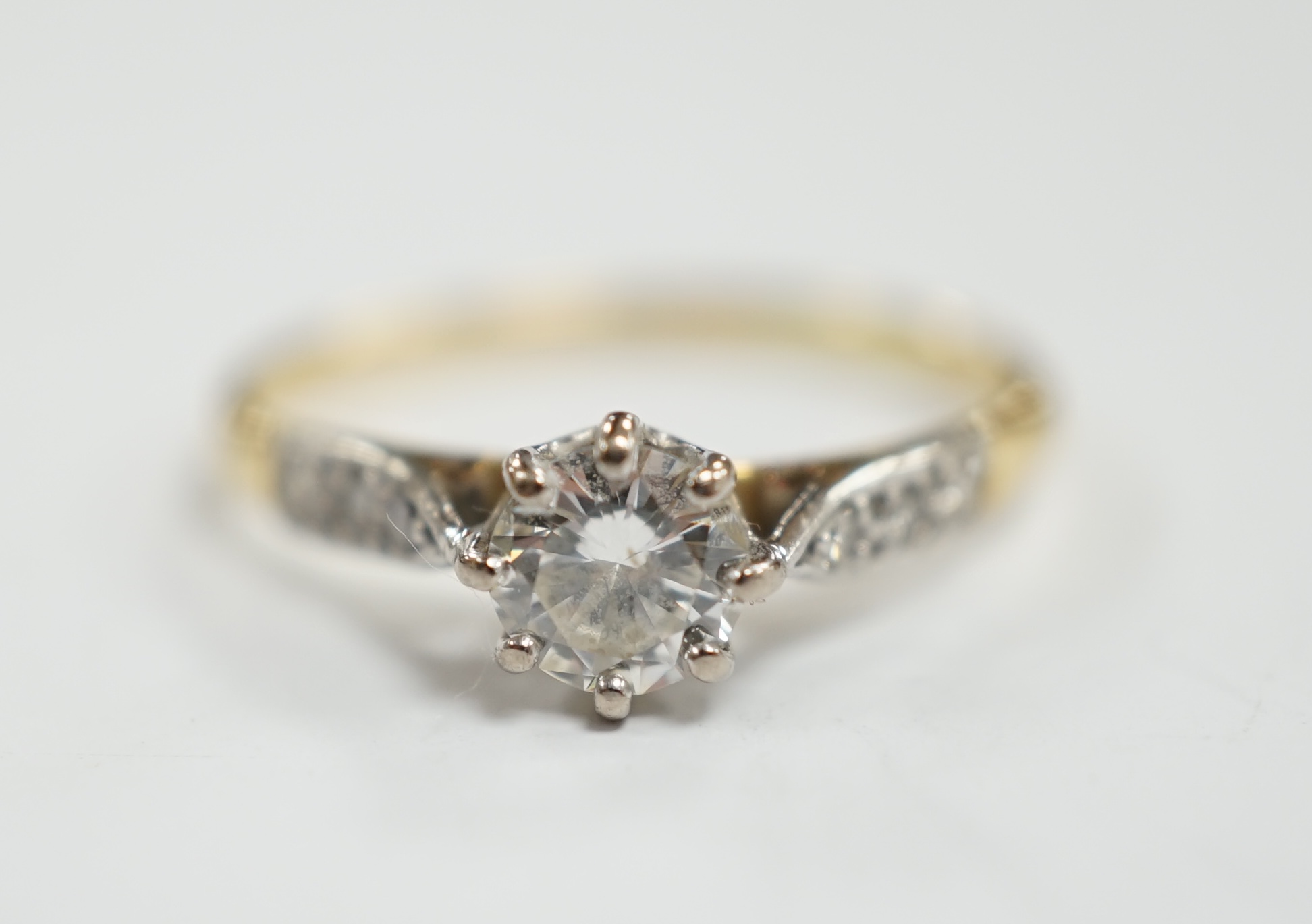 An 18ct and single stone diamond set ring, with diamond chip set shoulders, size M, gross weight 1.9 grams.